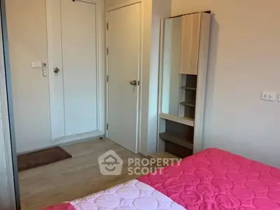 Cozy bedroom with pink bedding and modern wardrobe in a stylish apartment.