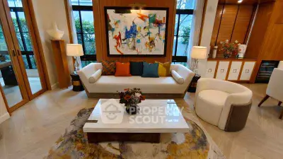 Luxurious living room with modern art, elegant furniture, and large windows for natural light.