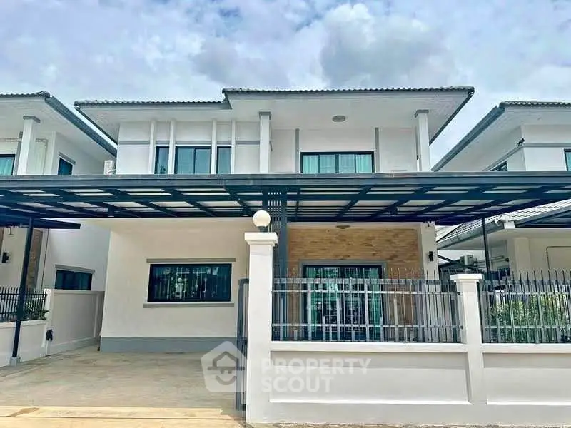 Modern two-story house with spacious driveway and sleek exterior design.