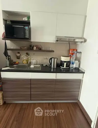 Compact modern kitchen with sleek cabinets and appliances, perfect for urban living.