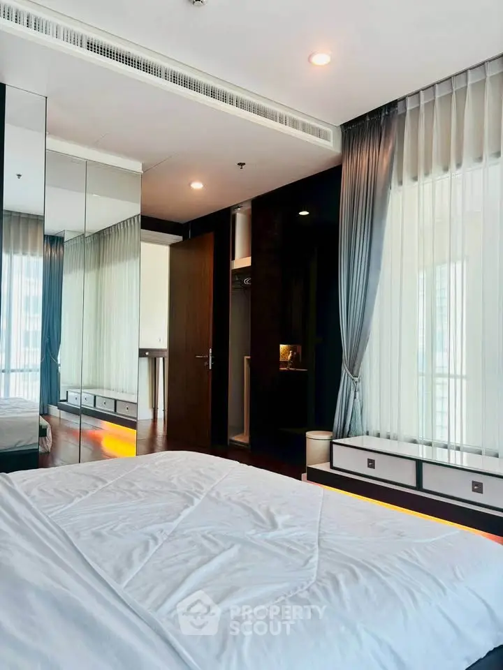 Luxurious bedroom with modern decor and large windows offering ample natural light.