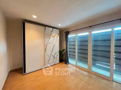 Spacious bedroom with large windows and modern sliding closet doors