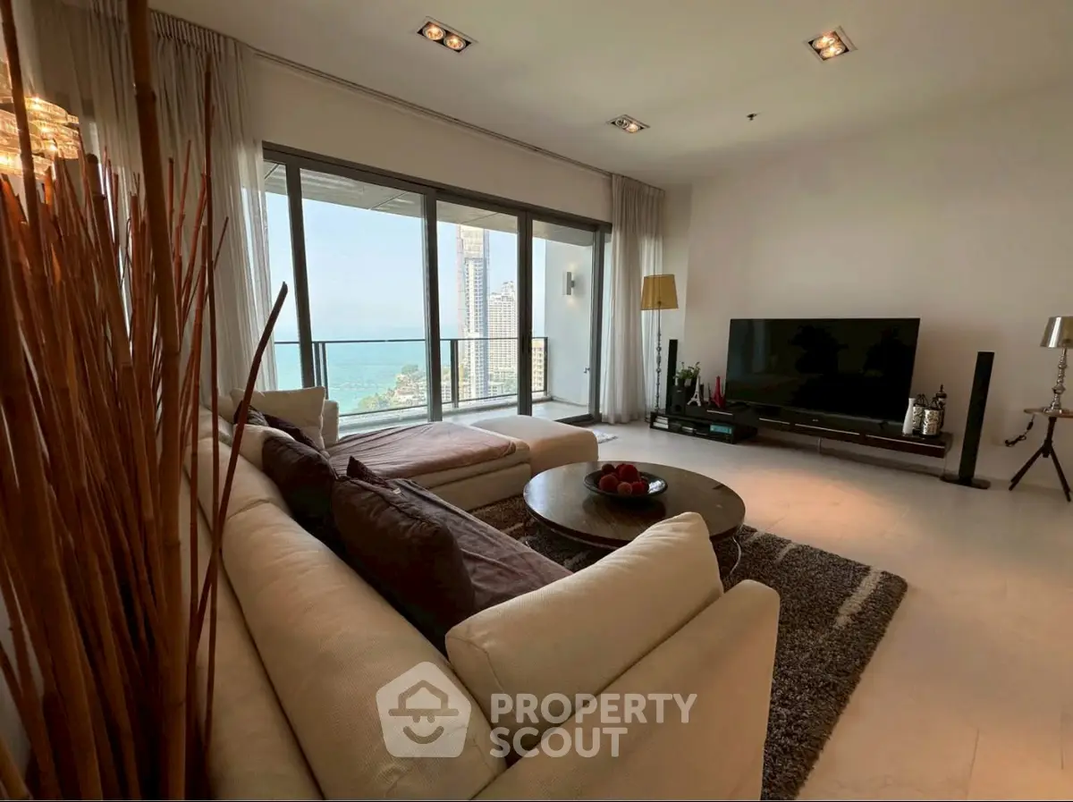 Luxurious living room with stunning ocean view and modern decor in high-rise apartment.