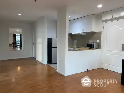 Modern open-layout kitchen with sleek appliances and wooden flooring