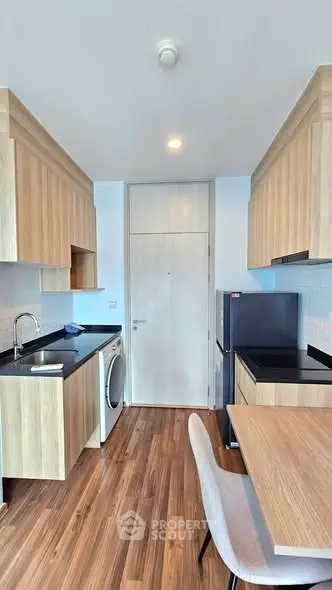 Modern kitchen with wooden cabinets, sleek countertops, and integrated appliances in a stylish apartment.