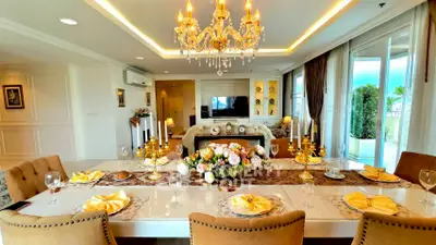 Luxurious dining room with elegant chandelier and beautifully set table in a spacious living area.