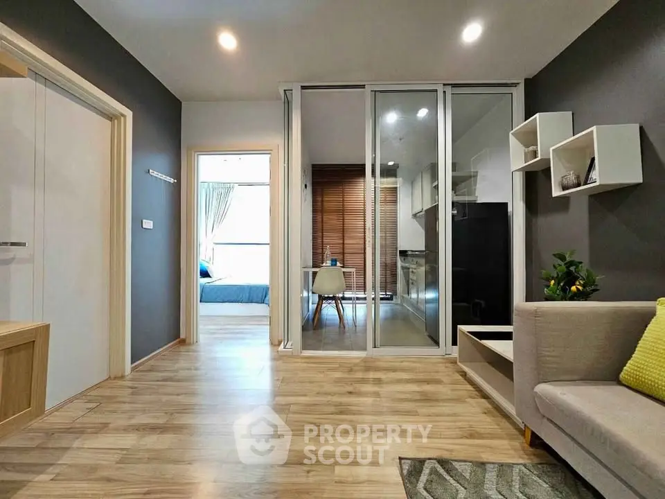 Modern living room with open layout and stylish decor, featuring a view into a cozy bedroom.