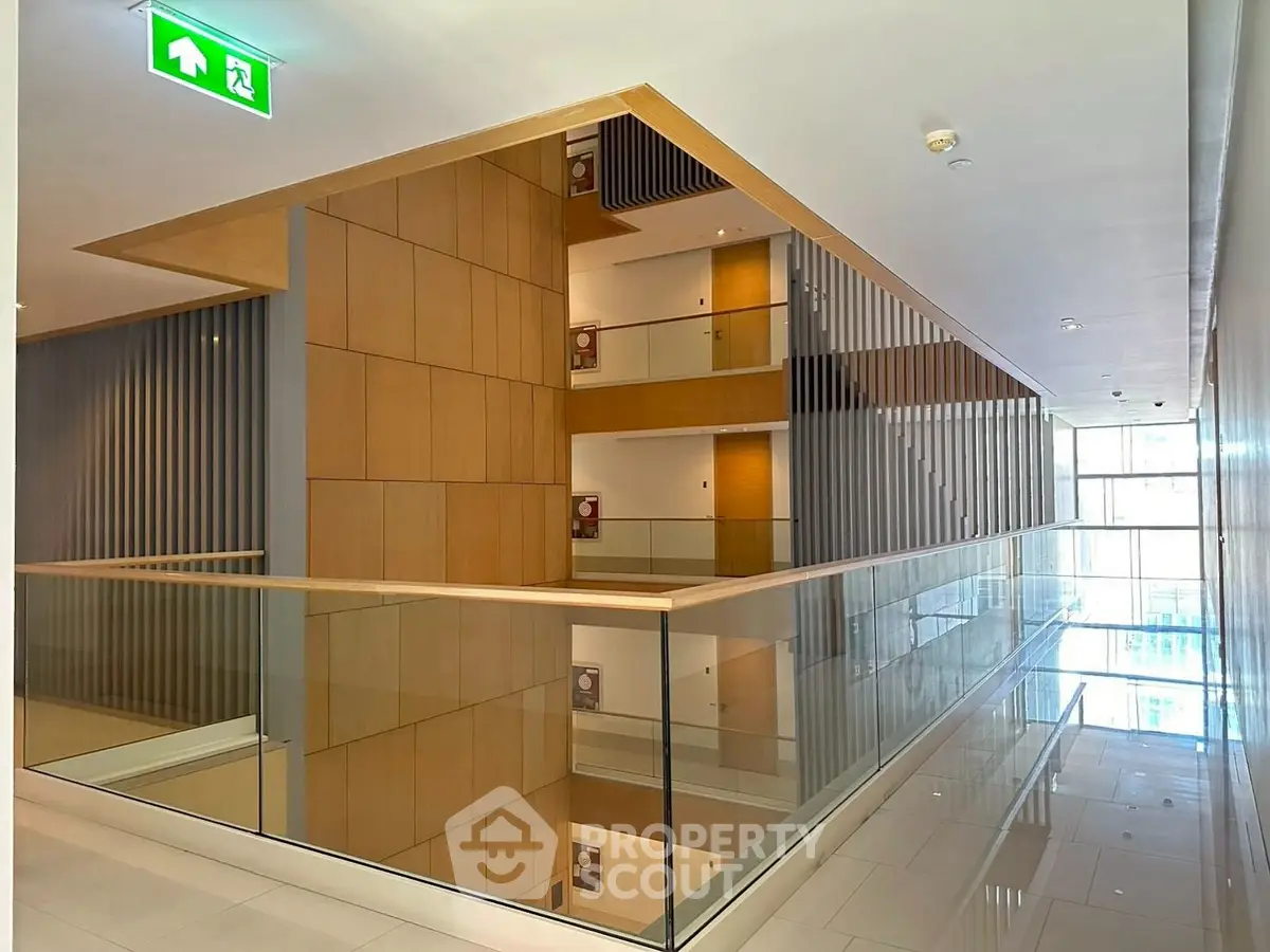 Modern building interior with sleek glass railings and wooden panel accents