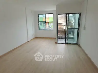 Spacious empty room with large window and balcony access, perfect for customization.