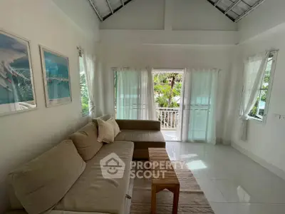 Bright living room with cozy sofa and balcony view, perfect for relaxation.
