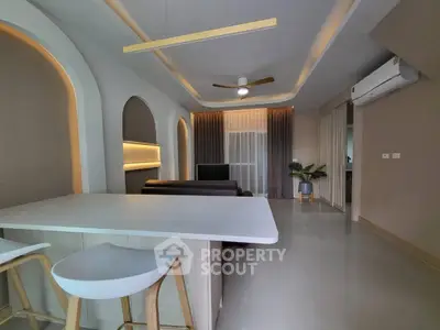 Modern living room with stylish lighting and open layout, featuring a sleek ceiling fan and air conditioning.