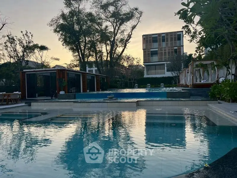 Luxurious residential pool area with modern architecture and serene ambiance at sunset.