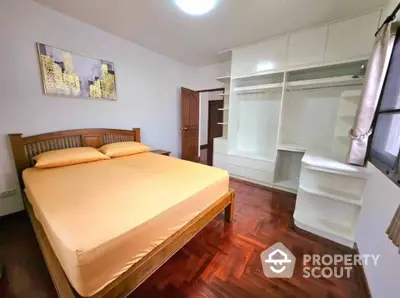 Spacious bedroom with wooden flooring and built-in wardrobe