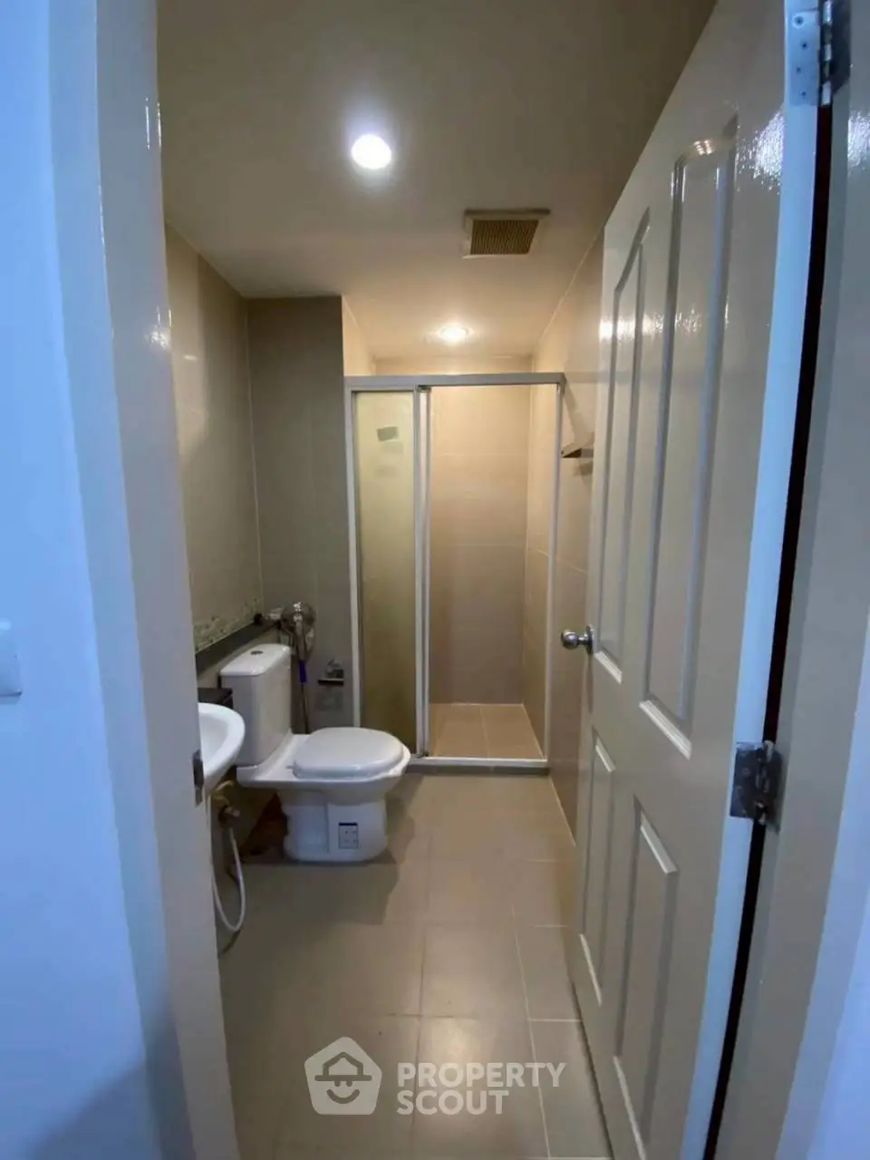 Modern bathroom with shower and toilet in a sleek apartment unit.