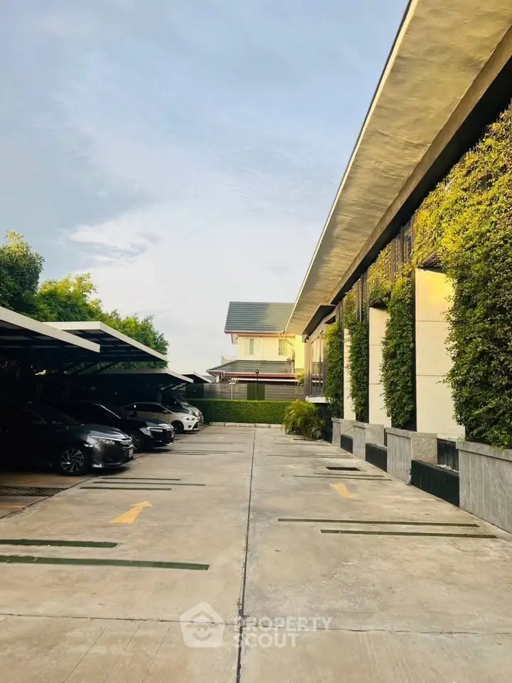 Modern residential parking area with lush greenery and sleek architecture.
