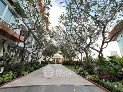 Beautiful garden pathway with lush greenery and modern building facade