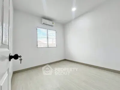 Spacious empty room with air conditioning and bright window view, perfect for customization.