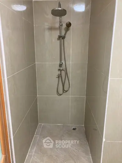Modern shower area with sleek fixtures and neutral tiles