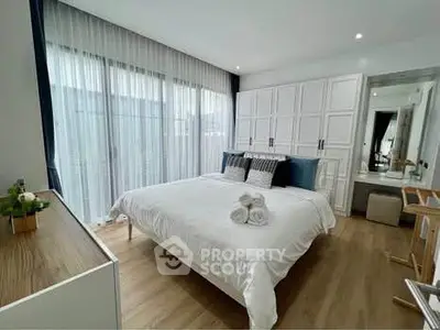 Elegant bedroom with modern decor and large windows in a stylish apartment.