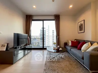 Modern living room with large window and city view, featuring stylish furniture and decor.