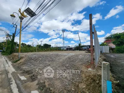 Vacant land plot with clear blue sky, ideal for development opportunities.