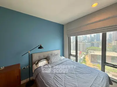 Modern bedroom with city view, featuring a cozy bed and stylish decor in a high-rise apartment.