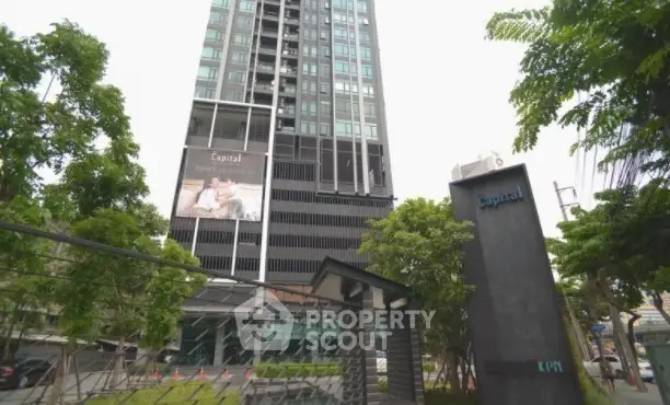 Modern high-rise building with lush greenery and sleek architectural design.