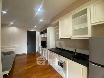 Modern kitchen with sleek cabinets and hardwood floors in a cozy apartment.