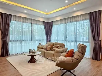 Luxurious living room with modern furniture and large windows offering natural light.