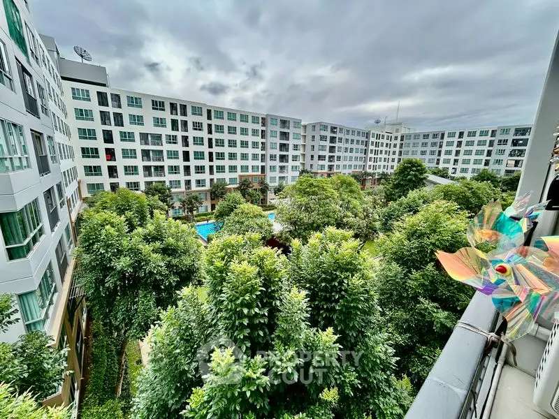 Stunning view of modern apartment complex with lush green garden and pool