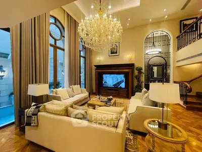 Luxurious living room with elegant chandelier and high ceilings in upscale property