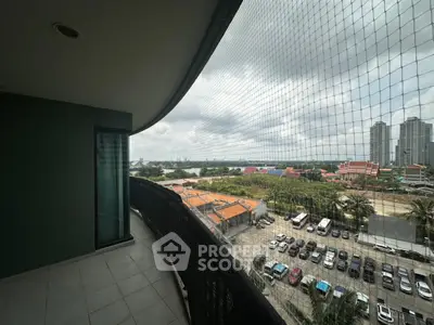 Spacious balcony with panoramic city view and safety netting, perfect for relaxation and enjoying the skyline.