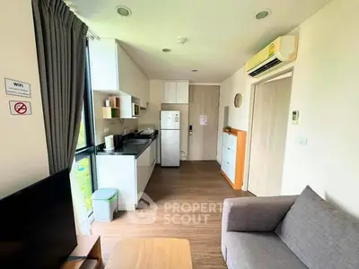Modern apartment interior with open kitchen and cozy living area, featuring sleek appliances and stylish decor.