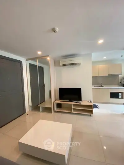 Modern living room with sleek furniture and open kitchen layout in a stylish apartment.
