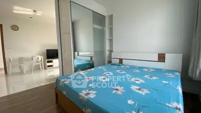 Modern bedroom with floral bedding and mirrored closet in a bright apartment