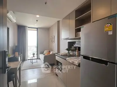 Modern open-plan kitchen and living room with sleek appliances and cozy decor.