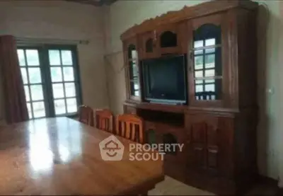 Charming living room with wooden furniture and large windows for natural light.