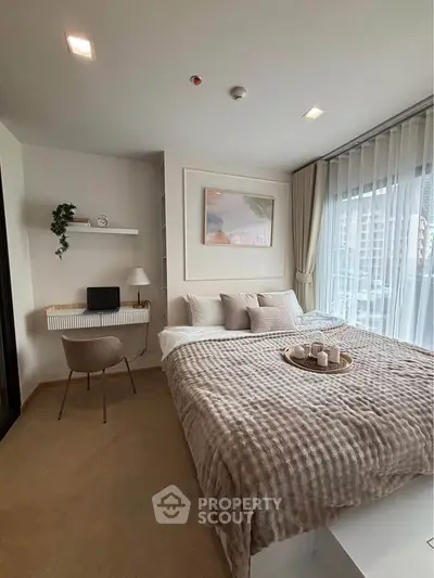 Modern bedroom with cozy decor and large window offering city view