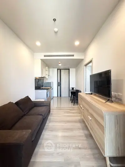 Modern living room with sleek furniture and open kitchen layout in a stylish apartment.