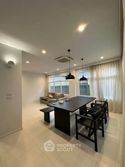 Modern living room with sleek furniture and large windows for natural light.