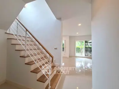 Spacious modern interior with elegant staircase and bright living area, perfect for family living.