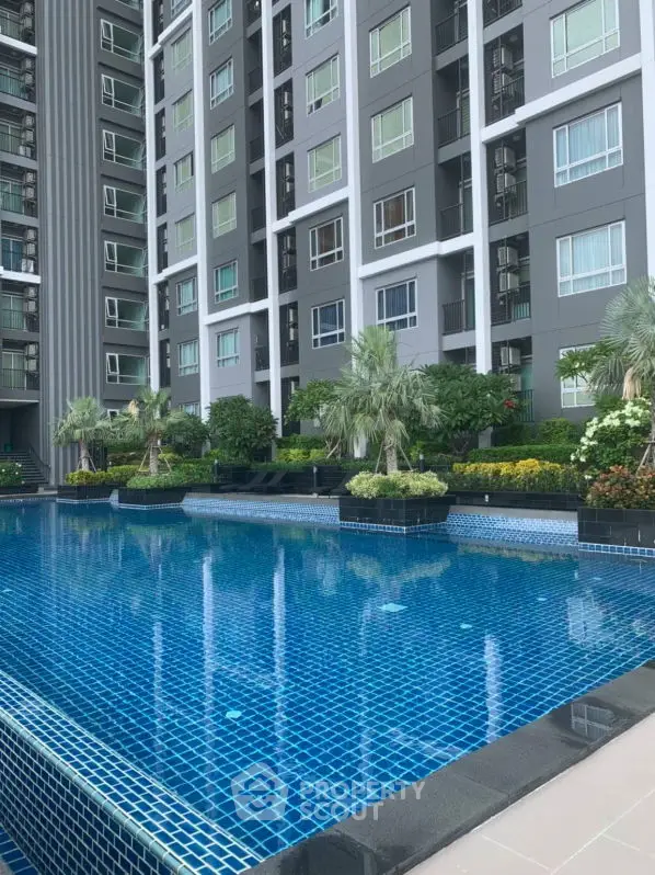 Modern residential building with stunning pool and lush garden landscaping.