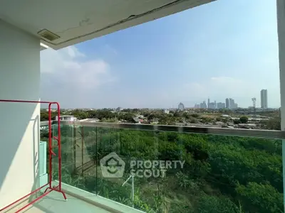 Spacious balcony with stunning city skyline view and lush greenery, perfect for relaxation and enjoyment.