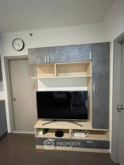 Modern living room with sleek TV unit and wall clock, perfect for contemporary urban living.