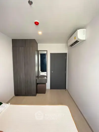 Modern bedroom with sleek design, featuring built-in wardrobe and air conditioning for ultimate comfort.