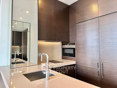 Modern kitchen with sleek cabinetry and built-in appliances in luxury apartment.