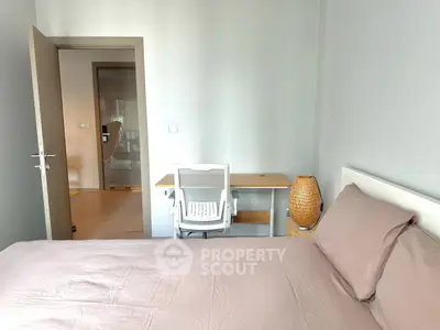 Cozy bedroom with modern desk and chair, perfect for a home office setup.