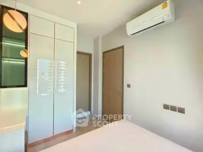 Modern bedroom with sleek wardrobe and air conditioning in a bright apartment.