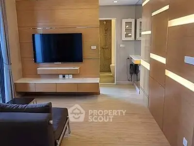 Modern living room with sleek wooden paneling and wall-mounted TV, leading to a stylish bathroom.