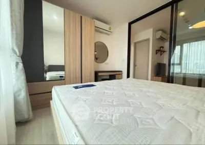 Modern bedroom with stylish decor and ample natural light, featuring a comfortable bed and sleek furniture.